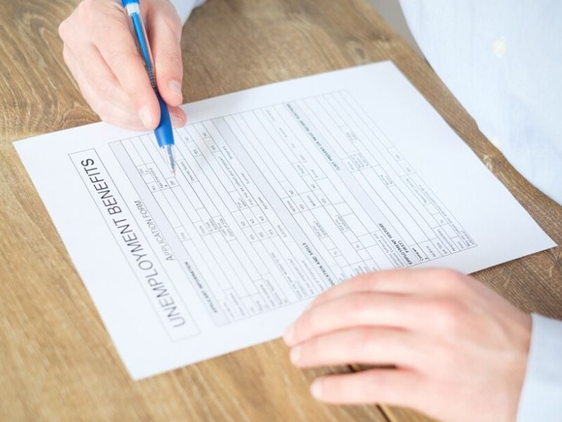 person filling up unemployment benefits form