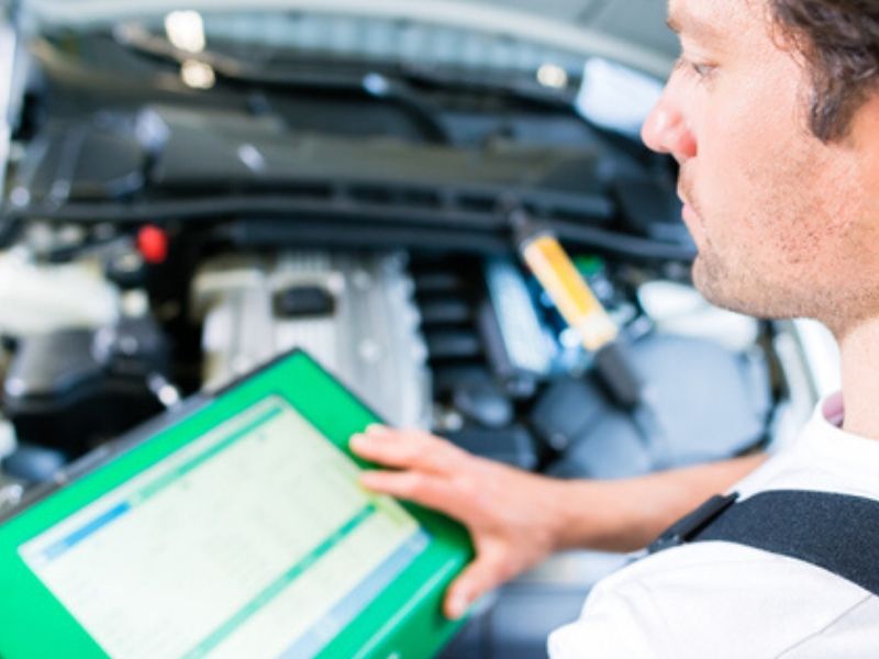 car mechanic with diagnostic tool