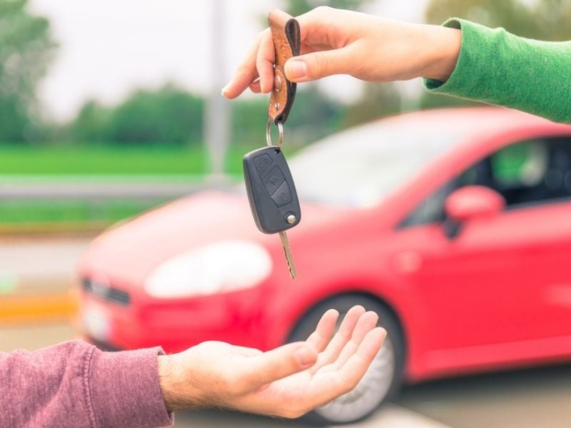 one person sells car and gives the key to the new owner