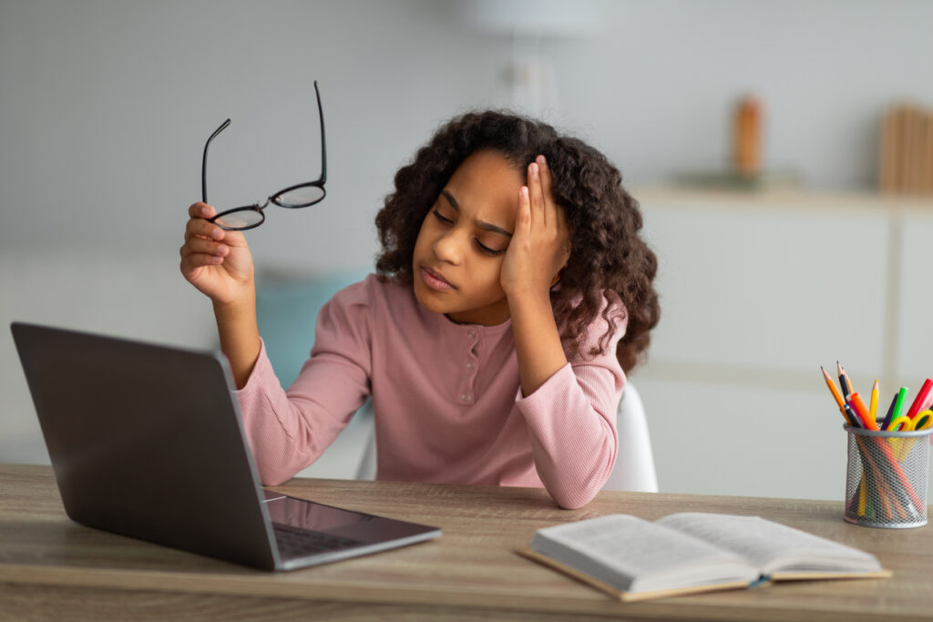 Little girl studying with a headache