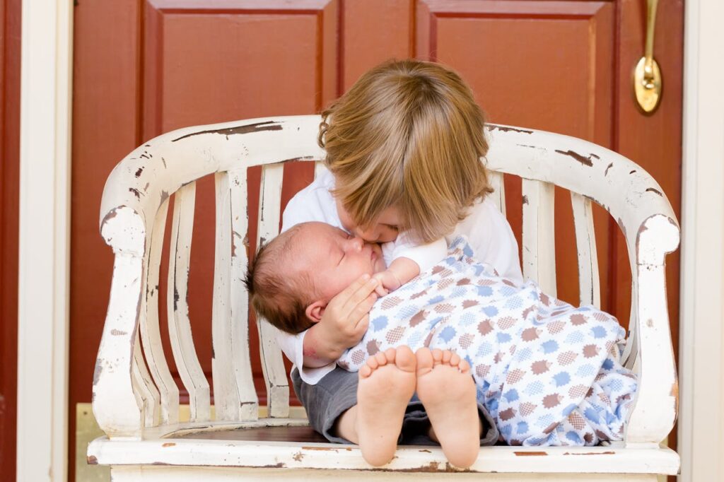 Photo by Pixabay: https://www.pexels.com/photo/boy-carrying-and-kissing-baby-sitting-on-chair-50601/