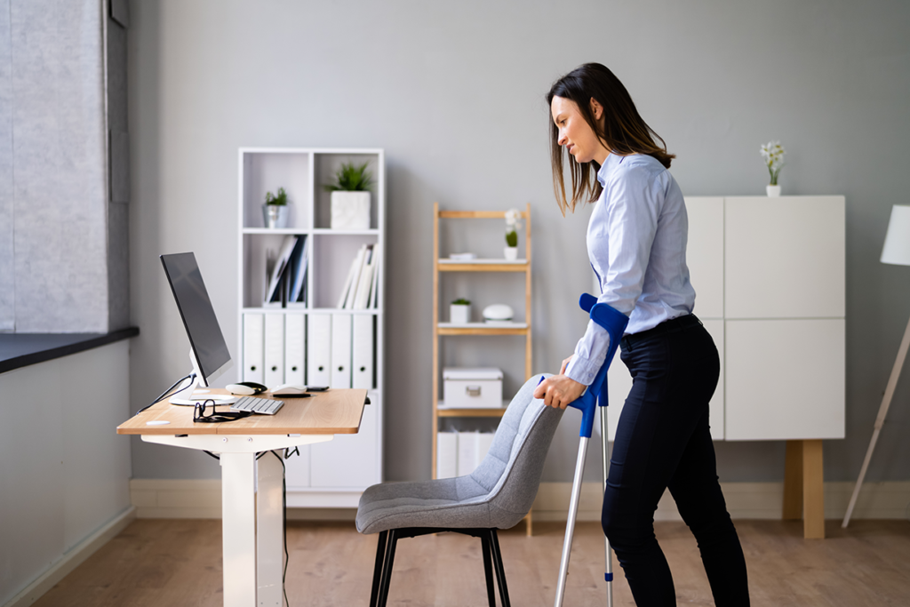 Woman leaning on her desk looking at her computer
