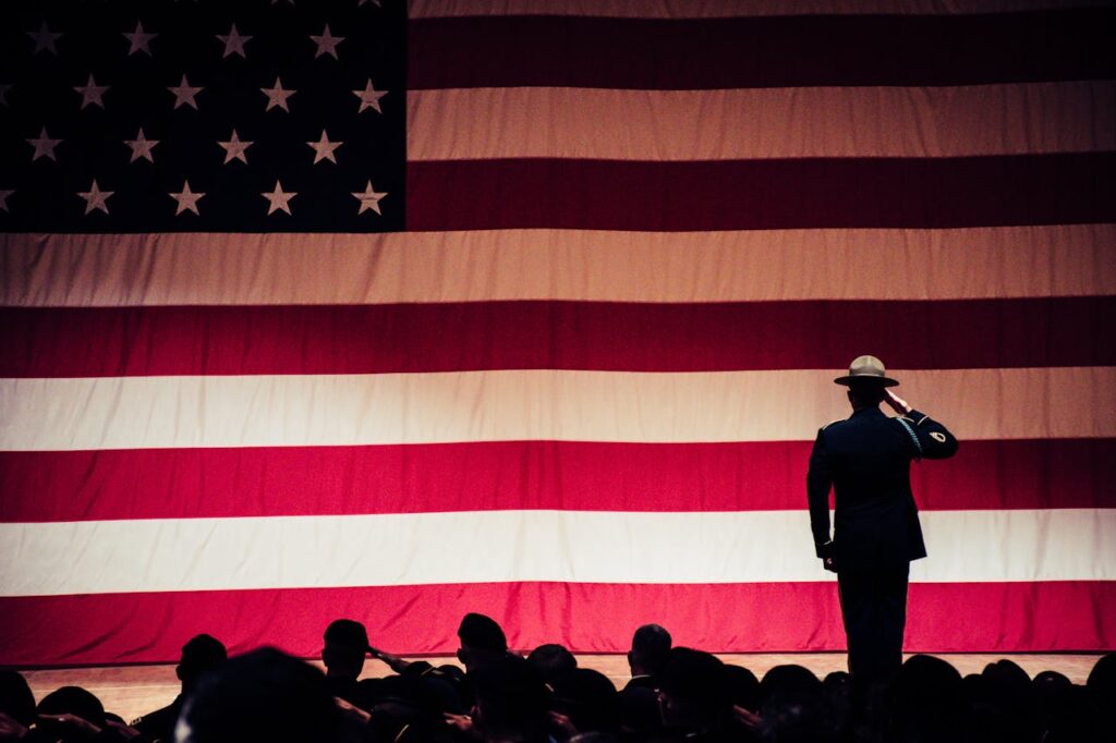 Photo by Brett Sayles: https://www.pexels.com/photo/man-standing-on-stage-facing-an-american-flag-1340504/