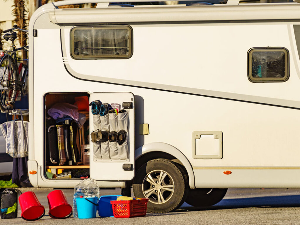 Camper car in maintenance service. Cleaning and preparing motorhome at caravan campsite outside. Holidays with mobile home.